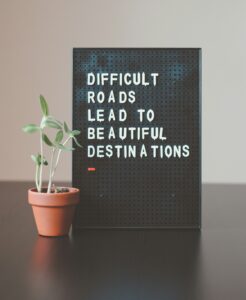 a board displaying the message: Difficult roads lead to beautiful destinations